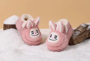Detailed view of pink fluffy toddler winter shoes featuring a cute cartoon rabbit face.
