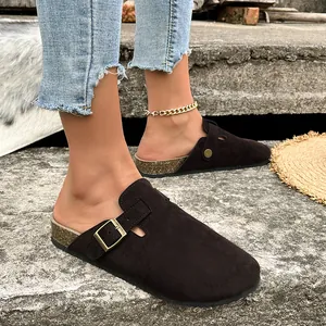 Primo piano di sabot in pelle scamosciata marrone con fibbia regolabile sui piedi