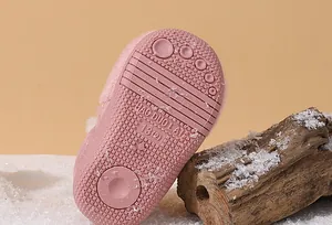 Detail of the anti-slip pink rubber sole on a toddler's warm winter snow boot.
