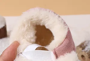 Detailed macro view of the thick warm faux fur lining inside children's pink winter snow boots
