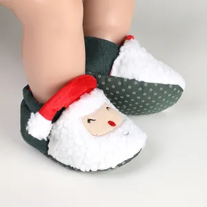 Detailed view of white plush Santa Claus baby booties with non-slip dotted green soles