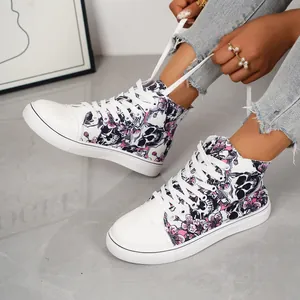 Detailweergave van hoge canvas sneakers met roze bloem- en schedelpatronen
