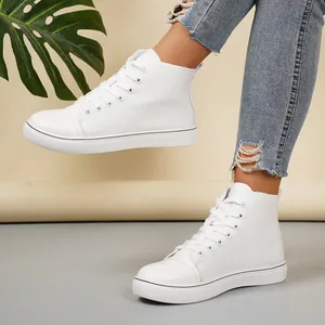Detailweergave van stijlvolle witte hoge canvas sneakers gedragen met gescheurde spijkerbroek.