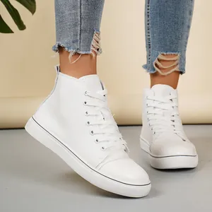 Close-up van witte hoge canvas sneakers gedragen met gescheurde jeans voor studenten