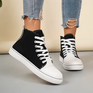 Detail van zwart-witte hoge canvas sneakers met vetersluiting voor dames en heren