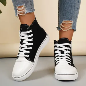Detailopname van trendy zwart-witte high-top canvas sneakers met witte veters.