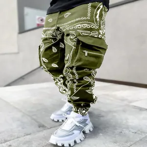 Close-up of olive green cargo pants featuring a white paisley print and zipper pocket