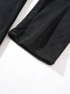 Close-up of soft black coral fleece fabric texture and cuff stitching on men's sweatshirt.