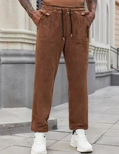 Detailed view of brown fleece drawstring sweatpants with embroidered logo on side pocket.