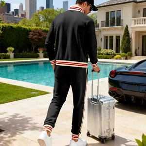Back view of men's black tracksuit with striped trim in a luxury poolside setting