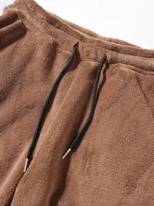 Close-up detail of soft brown fleece sweatpants with black adjustable drawstring