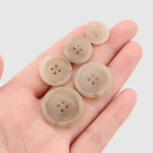 Boutons ronds classiques en résine haut de gamme dans les tons marron tenus à la main