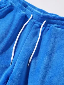 Close-up detail of soft blue fleece sports pants featuring a white adjustable drawstring