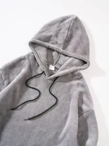 Close-up detail of a soft grey fleece hoodie with black drawstrings and fuzzy texture.