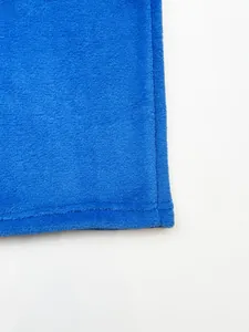 Close-up detail of blue fleece pants showing hem stitching and soft fabric texture.