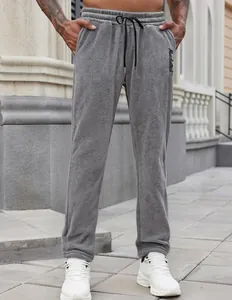 Close-up detail of grey men's fleece joggers featuring drawstring waist and pockets.