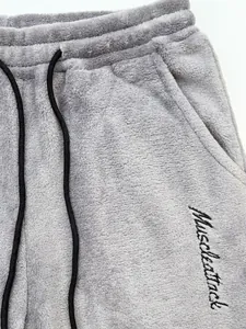 Close-up view of the soft grey plush fleece fabric with Muscleattack embroidered logo