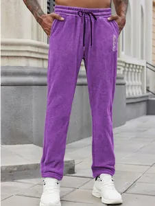 Detailed macro view of men's purple fleece leisure pants with drawstring and embroidery
