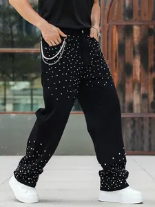 Detailed shot of men's black straight jeans with sparkling rhinestone embellishments.