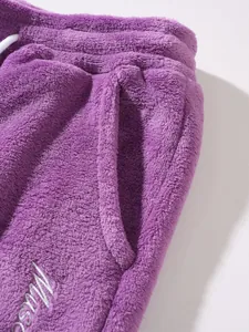 Close-up of purple fleece pants showing soft fabric texture and side pocket detail