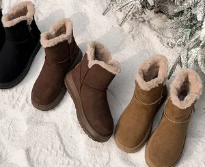 Close-up of plush-lined winter snow boots in various colors on snow background