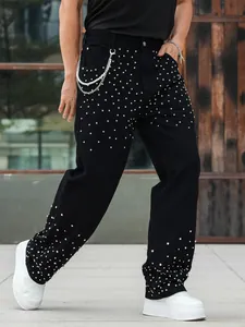 Close-up of men's black straight-leg jeans with sparkling rhinestone studs