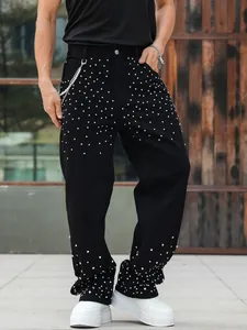 Detailed shot of men's loose black denim jeans with sparkling rhinestone embellishments