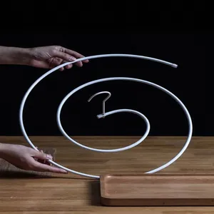 White spiral drying rack for large bedsheets and quilts on minimalist wooden table