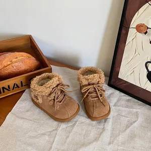 Cozy tan toddler snow boots with faux fur lining and laces in a warm lifestyle setting