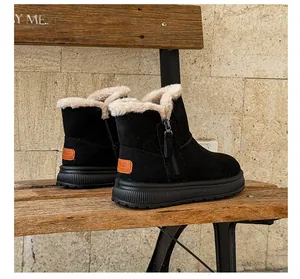 Side view of black snow boots with warm faux fur lining on a rustic wooden bench.
