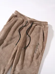 Detailed view of men's brown fleece drawstring joggers with Muscleattack embroidery detail