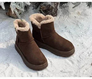 Detailed side view of brown suede snow boots with thick fur lining on snowy winter background