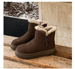 Side view of brown fleece-lined snow boots with zipper detail on a wooden bench