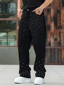 Detailed view of black straight-leg jeans for men with scattered rhinestone stud accents