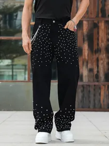 Detail view of men's loose straight jeans featuring sparkling rhinestone studs