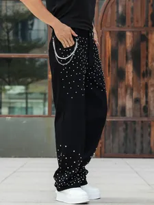 Side view of men's black loose straight jeans decorated with sparkling silver rhinestones