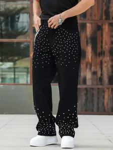 Detail shot of black men's loose straight jeans featuring sparkling rhinestone embellishments