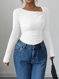 Détail d'un haut en maille côtelée blanche avec un décolleté asymétrique unique.