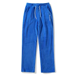 Detail view of blue plush men's sweatpants featuring drawstring and embroidered logo