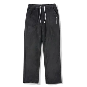 Detail of men's fuzzy black joggers with white drawstring and embroidery.