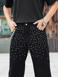 Mens black rhinestone studded denim jeans in a loose straight fit streetwear style