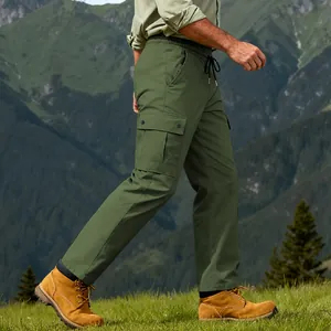 Vista laterale di pantaloni cargo outdoor verde oliva da uomo in un ambiente montano