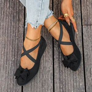 Vista dettagliata delle scarpe scamosciate nere da donna con fiocco e lacci incrociati