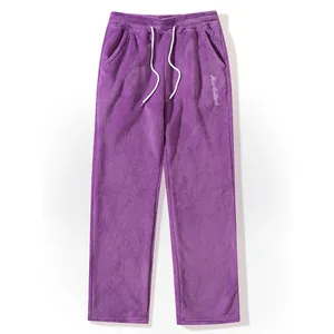 Close-up view of men's purple fleece casual pants featuring white drawstring and embroidery.