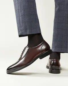 Vue détaillée de chaussures Derby en cuir marron pour hommes avec pantalon gris