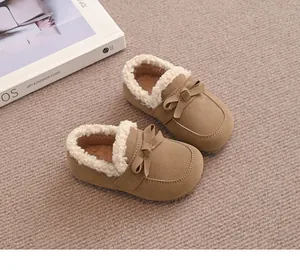 Nahaufnahme warmer brauner Baby-Mokassins mit beigem Fellfutter und Schleife