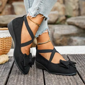 Vista dettagliata delle scarpe zeppa in camoscio nero con cinturini elastici