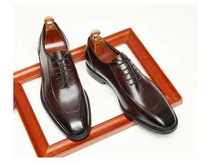 Vue détaillée de chaussures de ville en cuir marron sur un support de cadre en bois.