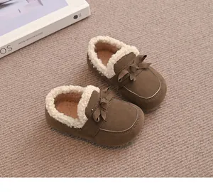 Nahaufnahme der braunen Winter-Slipper für Mädchen mit warmem Fleecefutter und Schleife.