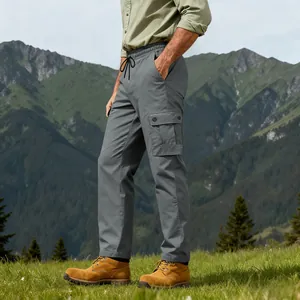 Pantaloni cargo tattici da uomo grigi con tasche multiuso in un paesaggio di montagna